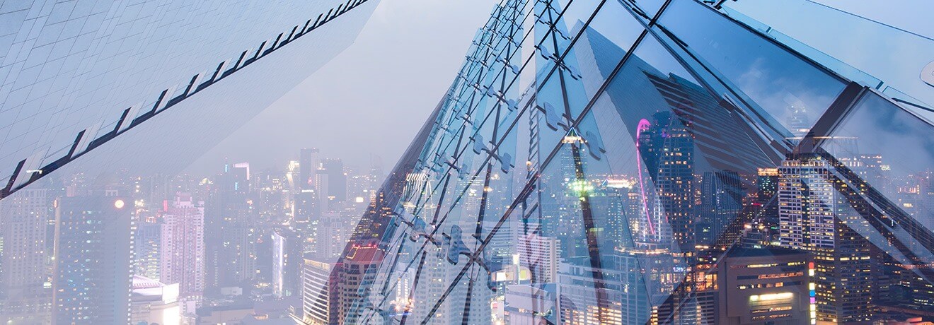 Skyline urbano con grattacieli in vetro che rappresentano servizi integrati di real estate e asset management.