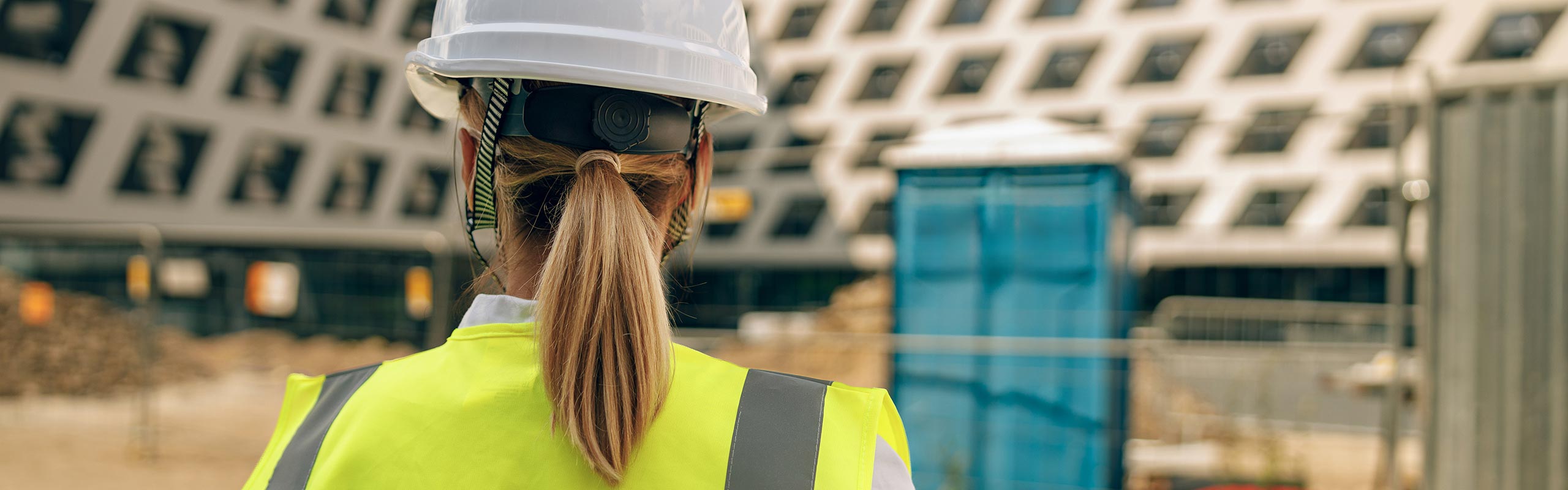 Construction site technician inspecting a building under construction for asset integrity and structural asset management services