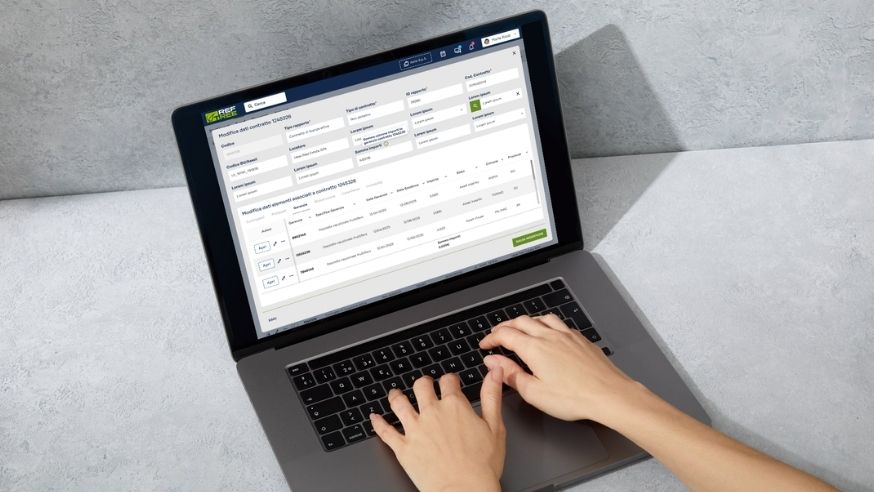 Persona al lavoro su un laptop con documento digitale, a rappresentare processi di gestione documentale e digitalizzazione nel real estate.