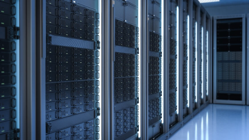 Corridoio di data center con file di server rack illuminati da luci blu, simbolo di infrastrutture digitali e capacità computazionale.
